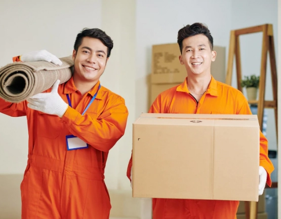 movers-carrying-carpet-cardboard-box_274689-11596